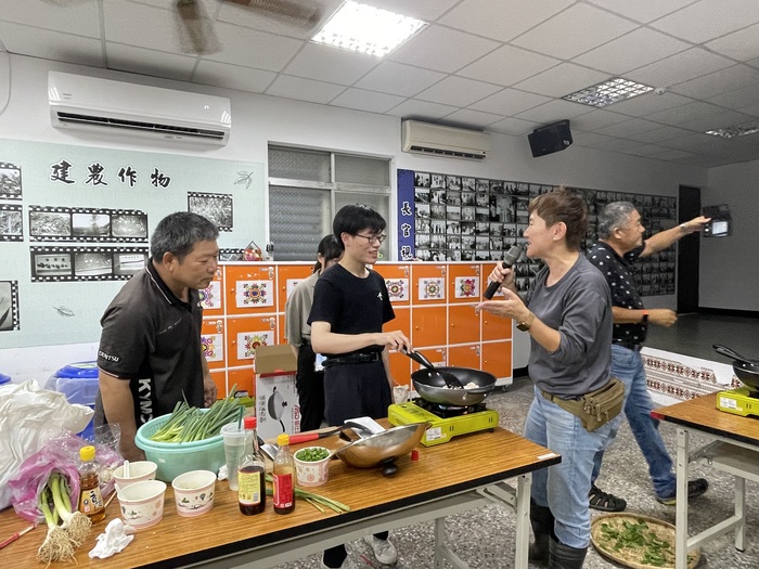 生肉組的同學們一邊煎肉，一邊向大家介紹這道菜的來歷，以及他們向社區居民學習的過程